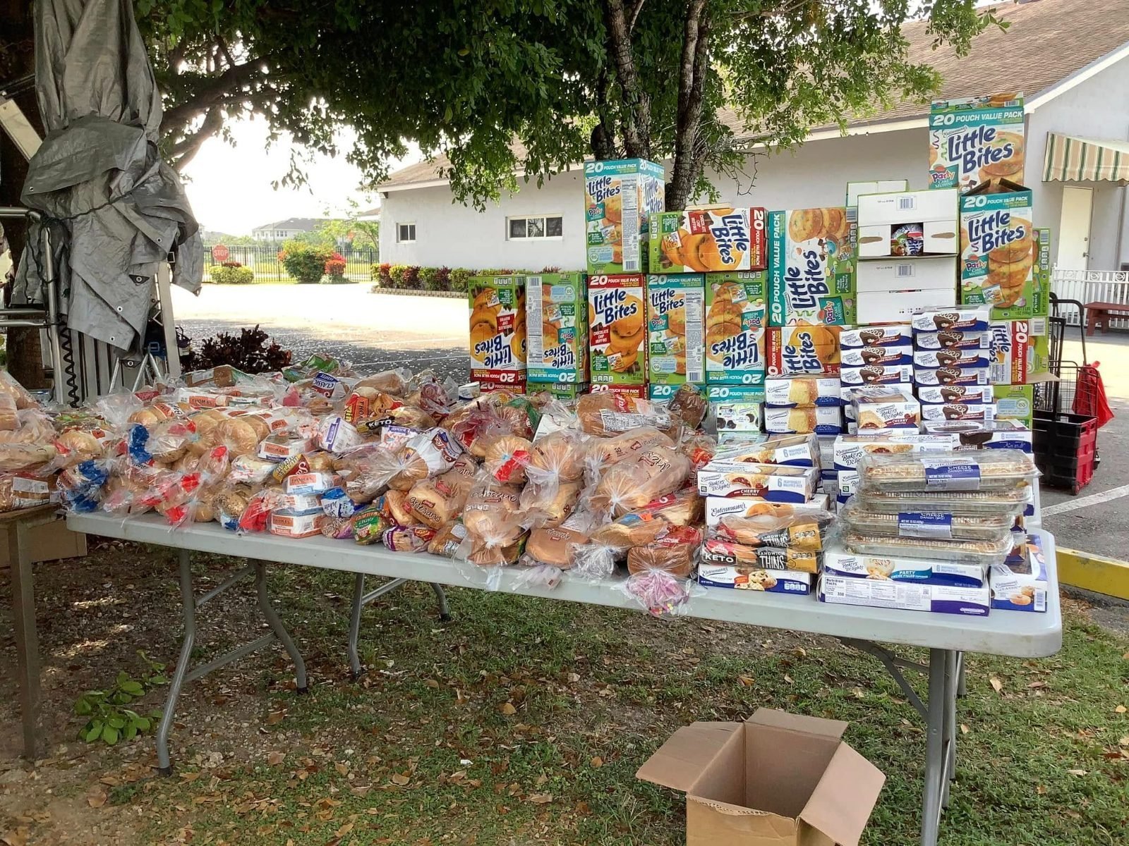 Voluntarios entregando bandejas de comida caliente a las familias de la comunidad