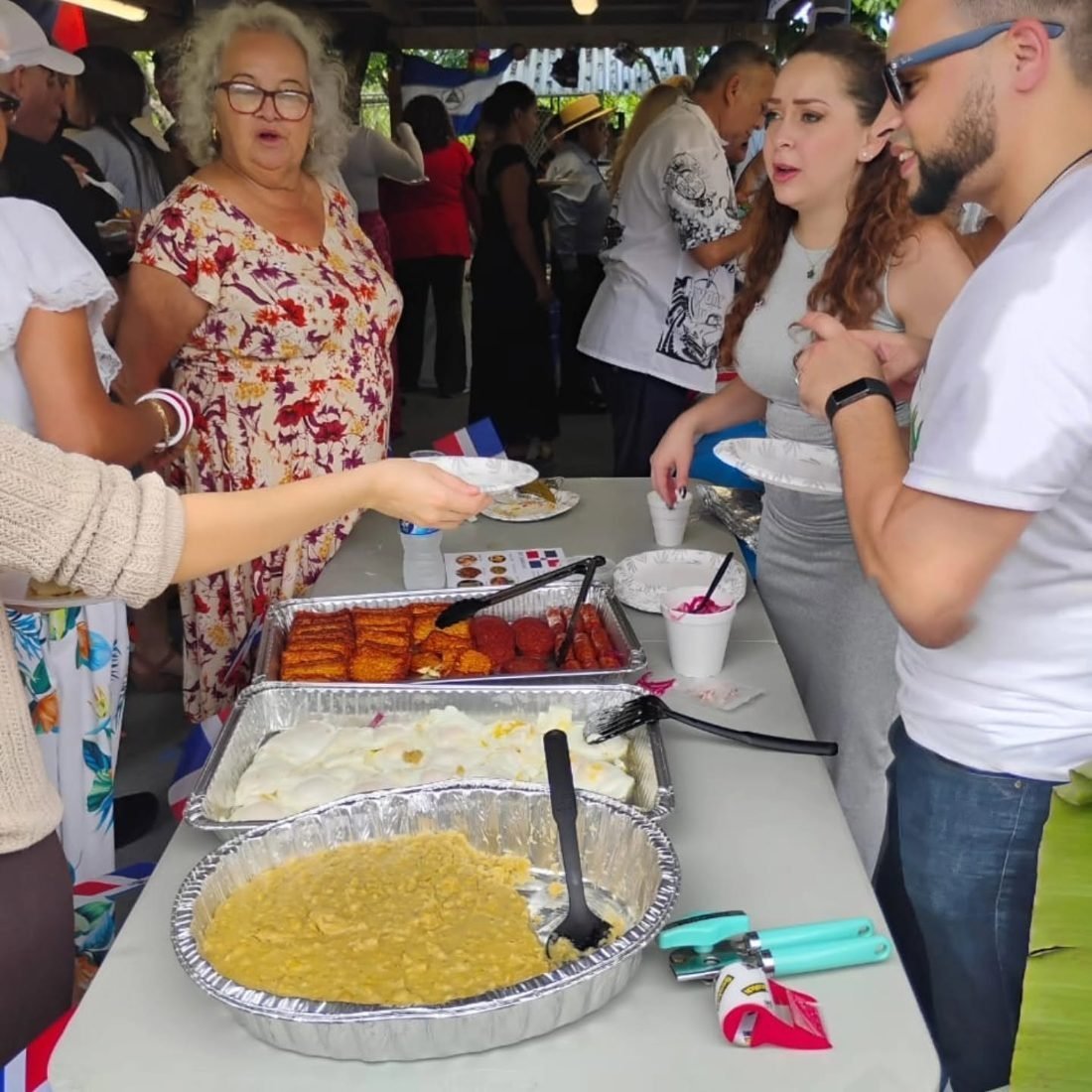 Manos entregando un plato de comida a una persona de la comunidad